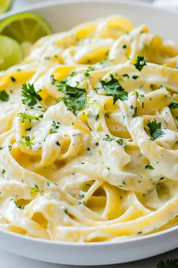 - 12 oz (340g) fettuccine or linguine - 1 cup heavy cream - ½ cup grated Parmesan cheese - ¼ cup fresh cilantro, finely chopped - 2 tablespoons fresh lime juice (about 1 medium lime) - 1 clove garlic, minced - 1 tablespoon olive oil - Salt and freshly ground pepper to taste - Extra cilantro leaves and lime slices for garnish When you gather your ingredients, focus on freshness. Fresh cilantro brings a bright taste, while lime adds a zesty kick. Heavy cream and Parmesan cheese make the dish rich and creamy. You can use fettuccine or linguine based on your preference. Both types work great with the sauce. Make sure to have all your ingredients prepped before starting. Chop the cilantro finely, zest the lime, and mince the garlic. This step saves time and keeps the flow smooth as you cook. Always taste your sauce before serving. Adjust the seasoning to fit your taste. A pinch of salt and pepper can elevate the flavors. Remember, the garnish is not just for looks. Extra cilantro and lime slices add freshness and color to your dish. Enjoy the process of creating this delightful meal! {{ingredient_image_2}} 1. Start by bringing a large pot of salted water to a rapid boil. This step is key for flavor. 2. Add 12 oz of fettuccine or linguine. Cook it until al dente, which means firm to the bite. 3. Before draining, reserve about 1 cup of the pasta cooking water. This water helps make the sauce creamy. Drain the pasta and set it aside in the pot. 1. In a large skillet, heat 1 tablespoon of olive oil over medium-low heat. Wait until it’s hot. 2. Add 1 clove of minced garlic. Sauté it for about 1 minute. It should smell fragrant but not burnt. 1. Slowly pour in 1 cup of heavy cream. Stir it constantly to mix well. 2. Bring the mixture to a gentle simmer. Then, add ½ cup of grated Parmesan cheese. Stir until it melts and thickens the sauce. 3. Mix in 2 tablespoons of fresh lime juice, the zest of 1 lime, and ¼ cup of finely chopped cilantro. Add salt and pepper to taste. If it's too thick, add some reserved pasta water. 1. Add the drained pasta into the skillet. Toss gently to coat each strand with sauce. 2. Let it cook on low heat for an extra 2-3 minutes. This melds the flavors well. 1. Plate the creamy cilantro lime pasta in serving bowls. Make sure it looks generous and inviting. 2. Garnish with extra cilantro leaves and lime slices. This adds color and freshness. - Importance of Reserved Pasta Water: Always save some pasta water before draining. This starchy water helps bind the sauce to the pasta, creating a silky texture. It also adds flavor and moisture. - Slow Incorporation of Ingredients: When you add cream to the garlic, do it slowly. Stir as you pour to blend well. This step is key for a smooth sauce. Adding cheese should be gradual, too. This helps it melt evenly without clumping. - Tips for Adjusting Flavor Intensity: Start with less lime juice and cilantro. You can always add more if needed. Taste as you go. This way, you can find your perfect balance. - Avoiding Overpowering Cilantro: Cilantro can be strong. If you’re unsure, use half the amount at first. You can always add more later. This keeps the lime flavor bright and fresh without being lost. - Monitoring Sauce Thickness: Keep an eye on your sauce as it cooks. If it gets too thick, add more reserved pasta water. This will keep it creamy and easy to mix with the pasta. - Ideal Cooking Temperatures: Use medium-low heat when cooking your sauce. This prevents burning and allows the flavors to meld. A gentle simmer is best for creamy sauces, so adjust your heat as needed. Pro Tips Perfect Pasta Texture: Cook the pasta until al dente to ensure it retains a slight bite, which helps it hold up against the creamy sauce. Fresh Ingredients Matter: Use fresh cilantro and lime for the best flavor. Dried herbs will not provide the same vibrant taste. Customize Your Creaminess: Adjust the thickness of the sauce by adding reserved pasta water gradually until you reach the desired creamy consistency. Garnish for Appeal: Enhance the presentation by garnishing with extra cilantro leaves and lime slices, which add color and freshness to the dish. {{image_4}} You can boost your creamy cilantro lime pasta with protein. - Grilled Chicken: Grilled chicken adds a nice flavor and texture. Simply slice it and toss it in with the pasta. It pairs well with the creamy sauce and lime. - Shrimp or Prawns: Shrimp or prawns work great too. Cook them in the skillet before adding the sauce. Their light taste complements the dish. Just sauté them until they turn pink, then mix them in. If you prefer a vegetarian option, there are tasty ways to make it work. - Adding Vegetables: You can add vegetables like bell peppers or zucchini. Sauté them briefly before adding the sauce. This adds color and crunch. - Using Vegan Cream Alternatives: For a vegan twist, use coconut cream or cashew cream instead of heavy cream. It gives a nice richness without dairy. To take the flavors up a notch, think about adding a few extras. - Incorporating Spices: Add chili flakes for a bit of heat. Just a pinch can make a big difference. Mix it in when you add the lime juice for a kick. - Adding Extra Cheese Varieties: You can try different cheeses too. Feta or goat cheese crumbles can add a nice tangy flavor. Just sprinkle some on top before serving. To keep your creamy cilantro lime pasta fresh, store it right. Place the leftovers in an airtight container. This helps keep moisture in and air out. Make sure to cool the pasta to room temperature before sealing it. This way, it stays tasty for longer. You can reheat your pasta in two ways: microwave or stovetop. For the microwave, place the pasta in a bowl and cover it. Heat it in short bursts, stirring in between to warm evenly. If you prefer the stovetop, add the pasta to a pan with a splash of water. Heat it on low, stirring gently. To restore the creaminess, add a bit more heavy cream or reserved pasta water. This helps bring back the smooth texture you love. In the fridge, your creamy cilantro lime pasta lasts for about 3 to 4 days. If you want to keep it longer, consider freezing it. Make sure to freeze in a safe, airtight container. When frozen, it can last for about 2 months. Just remember to thaw it overnight in the fridge before reheating. Enjoy your delicious pasta again soon! Fettuccine and linguine work best for this sauce. Both types are flat and hold the creamy sauce well. You can also try spaghetti or penne if you prefer. These shapes are great at catching all the flavors. Yes, you can prep parts of this dish ahead. Cook the pasta and store it in the fridge. Make the sauce and keep it separate. This helps keep the pasta from soaking up too much sauce. When ready to serve, just heat the sauce and mix it with the pasta. To add heat, try using red pepper flakes or diced jalapeños. You can also use a spicy chili sauce for a kick. Just add these ingredients to the sauce while it's cooking. Start with a little and taste as you go. Make it as spicy as you like! Absolutely! This recipe is great for meal prep. Portion it into containers for easy lunches. Store the pasta and sauce separately to keep everything fresh. It lasts about 3-4 days in the fridge. Just reheat when you're ready to enjoy. This dish blends creamy sauce with fresh flavors. We covered key ingredients like fettuccine, heavy cream, and cilantro. Following step-by-step instructions ensures a tasty meal. Tips helped you achieve the perfect texture and flavor balance. You can add proteins or veggies for variety. Storing and reheating leftovers keeps your dish fresh. Enjoy experimenting to make this recipe your own, and relish the delightful flavors it brings!