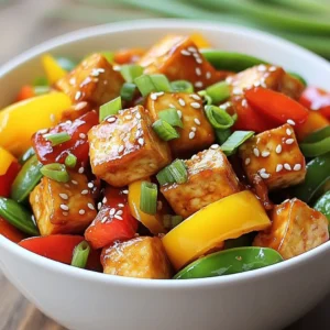 - 1 block of firm tofu, thoroughly drained and pressed - 1 red bell pepper, sliced into thin strips - 1 yellow bell pepper, sliced into thin strips - 1 cup snap peas, trimmed - 2 cloves garlic, finely minced - 1 tablespoon fresh ginger, minced - ¼ cup sweet chili sauce - 2 tablespoons soy sauce Tofu is the star of this dish. It soaks up flavors while giving a great texture. I prefer firm tofu for this recipe. It holds up well during cooking. Choose fresh, high-quality tofu for the best taste. Vegetables add color and crunch. I love using red and yellow bell peppers for their sweetness. Snap peas give a nice snap and freshness. You can mix and match other veggies based on your taste. Sauces bring everything together. Sweet chili sauce adds sweetness and a bit of heat. Soy sauce adds umami and saltiness. Together, they make a perfect blend for your stir-fry. - 2 tablespoons cornstarch - 2 tablespoons vegetable oil - 1 tablespoon sesame oil Cornstarch helps create a crispy layer on the tofu. It’s simple but effective. Tossing tofu in cornstarch before cooking makes it golden and crunchy. Vegetable oil is great for frying. It has a high smoke point, so it won’t burn. Sesame oil adds a nutty flavor at the end. Just a drizzle gives a lovely finish. - Chopped green onions, for garnish - Toasted sesame seeds, for garnish Green onions add a fresh bite. They also brighten the dish visually. Just chop them up and sprinkle on top before serving. Toasted sesame seeds add a crunchy texture. They give a nice nutty flavor too. A sprinkle of these seeds makes your stir-fry look fancy. {{ingredient_image_2}} To start, you need to cut the tofu. Chop it into 1-inch cubes. This size works best for frying. Next, press the tofu to remove excess water. You can use a clean kitchen towel for this. Place the towel on a plate and set another plate on top of the tofu. Let it sit for about 15 minutes. This step helps the tofu absorb flavors and stay crispy. Now, toss the tofu cubes in a bowl with cornstarch. Make sure each piece is well-coated. This coating gives the tofu its crispy texture when you fry it. In a large skillet or wok, heat vegetable oil over medium-high heat. You want the oil to shimmer; this means it's ready for cooking. Carefully add the cornstarch-coated tofu. Cook it for 8-10 minutes. Turn the tofu cubes often, so they brown evenly. When they are golden and crispy, take them out and place them on a paper towel-lined plate. This helps absorb extra oil. Now, use the same pan for the veggies. Add the sliced red and yellow bell peppers along with the snap peas. Stir-fry these colorful vegetables for about 3-4 minutes. You want them to soften but still be crunchy. Next, add the minced garlic and ginger. Stir everything together for 1-2 minutes. The garlic and ginger will fill your kitchen with a lovely aroma. Return the crispy tofu to the pan with the veggies. Pour in the sweet chili sauce and soy sauce. Gently toss everything to coat the tofu and vegetables well in the sauce. The sweet and savory flavors will blend nicely. Drizzle sesame oil over the stir-fry. Toss it all for one more minute. This step adds a rich flavor. Finally, remove the pan from heat. Garnish with chopped green onions and toasted sesame seeds. These toppings add a nice crunch and flavor. Enjoy your colorful and tasty Sweet Chili Tofu Stir-Fry! Pressing tofu is key to getting it crispy. When you press tofu, you remove excess water. This step lets the tofu absorb more flavors and helps it fry better. I use a clean towel and a heavy object to press it for about 30 minutes. Cook tofu at the right temperature. Heat your oil until it shimmers. This means it’s hot enough to fry the tofu. If the oil isn’t hot enough, the tofu will soak up oil and become soggy. For stir-frying, I love using bell peppers and snap peas. They add color and crunch. Other great options include broccoli, carrots, and zucchini. Use a mix of your favorites for a vibrant dish. Timing is crucial for perfect crunch. Add the veggies to the pan after the tofu. Stir-fry them for just a few minutes, until they soften but still have a bite. This keeps your stir-fry fresh and tasty. You can adjust the sweetness and spice of your sauce. If you like it sweeter, add more sweet chili sauce. To make it spicier, add a pinch of red pepper flakes or a splash of sriracha. If you want to switch things up, try other sauces. Teriyaki or hoisin sauce can add a fun twist. You can even mix your own sauce with soy sauce and ginger for a unique flavor. Pro Tips Press Tofu Thoroughly: Ensure your tofu is well-pressed to remove excess moisture, which helps achieve a crispy texture when frying. Use High Heat: Cooking the tofu on medium-high heat allows it to crisp up quickly, giving it a delightful texture that complements the stir-fry. Customize Vegetables: Feel free to mix and match your favorite vegetables in this stir-fry, such as broccoli, carrots, or zucchini, for added nutrition and flavor. Serve Immediately: For the best texture and flavor, serve the stir-fry right after cooking, as the tofu can lose its crispiness if it sits too long. {{image_4}} You can switch tofu for tempeh or chicken. Tempeh gives a nutty flavor and a firmer bite. Chicken adds a hearty touch and cooks quickly. For a non-vegetarian option, add shrimp. Shrimp cooks fast and pairs well with sweet chili sauce. Feel free to mix in other vegetables. Broccoli, carrots, or zucchini work great. You can also use seasonal vegetables. Asparagus in spring or squash in fall can add new tastes and colors to your dish. Making your own sweet chili sauce is easy. Combine sugar, vinegar, and chili flakes for a fresh taste. You can also experiment with different marinades. Try adding lime juice or garlic for a unique twist. Mixing sauces can enhance the flavor profile of your stir-fry. To store leftovers, let the stir-fry cool down first. Then, place it in an airtight container. This helps keep the flavors fresh. I recommend using glass or BPA-free plastic containers. They are great for storing food. You can also reuse old jars or takeout containers if they seal well. Freezing tofu stir-fry is easy. To do this, let it cool completely. Then, transfer it to freezer-safe bags or containers. Make sure to remove as much air as possible to avoid freezer burn. When you want to eat it, thaw it overnight in the fridge. Reheat it on the stove over low heat. Stir occasionally to warm it through without overcooking. In the fridge, this dish lasts about 3 to 4 days. Keep an eye out for signs of spoilage. If you see mold or an off smell, it’s best to toss it out. Freshness is key for enjoying your sweet chili tofu stir-fry! Yes, you can make this dish gluten-free. To do this, use gluten-free soy sauce. Look for brands labeled as gluten-free. Tamari is a great option, as it is naturally gluten-free. This way, you can enjoy the same sweet and salty taste without the gluten. You can serve this stir-fry with many side dishes. Fluffy jasmine rice pairs well and absorbs the sauce nicely. Quinoa is another healthy choice that adds protein. You can also try serving it with steamed broccoli or a fresh salad for extra crunch. Yes, frozen vegetables work well in this recipe. They are quick and easy to use. Just add them straight to the pan without thawing. Cook them a bit longer to make sure they heat through. This saves time and still gives you a tasty dish. Absolutely! This stir-fry is great for meal prep. Cook it ahead of time and store it in containers. It lasts for about 4 days in the fridge. To reheat, just warm it in the microwave or on the stove. This makes busy days so much easier! This post covered how to make a tasty Sweet Chili Tofu Stir-Fry. You learned about the main ingredients like tofu and vegetables, plus important pantry staples. I provided step-by-step instructions for cooking crispy tofu and stir-frying veggies. You also got tips for customizing flavors and storage advice. Remember, this dish can change with different proteins and sauces. Enjoy creating your own version! With practice, you'll master this easy and delicious meal.