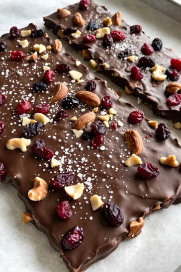For this treat, you need just a few simple ingredients: - 12 oz dark chocolate (70% cocoa or higher), chopped into small pieces - 1 cup mixed nuts (almonds, walnuts, and pecans), roughly chopped - ½ cup dried cranberries or cherries, chopped if large - ¼ cup unsweetened coconut flakes - 1 teaspoon flaky sea salt (plus extra for an additional sprinkle) Each ingredient plays a vital role in the flavor and texture of the bark. The dark chocolate brings rich flavor and a hint of bitterness. The mixed nuts add crunch and healthy fats. Dried fruit gives a sweet contrast, while coconut offers a tropical twist. Finally, flaky sea salt enhances every bite with a savory touch. - Dark Chocolate: This ingredient is high in antioxidants. It may lower blood pressure and improve heart health. - Mixed Nuts: Nuts are a great source of protein and healthy fats. They provide energy and support brain health. - Dried Cranberries or Cherries: These fruits are packed with vitamins and fiber. They can help with digestion and may boost immunity. - Coconut Flakes: Coconut adds healthy fats and fiber. It can help keep you full and satisfied. - Flaky Sea Salt: While salt is often seen as bad, a little can enhance flavor and balance sweetness. For the best taste, I recommend using high-quality dark chocolate. Look for brands like Ghirardelli or Lindt. They offer great options with at least 70% cocoa. For sea salt, try Maldon or Fleur de Sel. These brands provide a flaky texture that melts into the chocolate and adds a lovely crunch. Quality ingredients make a big difference in your final treat! {{ingredient_image_2}} Start by grabbing a baking sheet. Use one that is about 8x10 inches. Line it with parchment paper. Make sure the paper covers the whole surface. This helps with easy removal later. It also makes cleanup quick and simple. Next, take 12 ounces of dark chocolate. Chop it into small pieces. Place the chocolate in a microwave-safe bowl. Heat it in the microwave for 30 seconds. After that, take it out and stir well. Repeat this every 30 seconds until the chocolate is smooth. It should have no lumps. Be careful not to overheat it. Once the chocolate is melted, it&rsquo;s time to mix. Add in 1 cup of mixed nuts. You can use almonds, walnuts, and pecans. Next, toss in ½ cup of dried cranberries or cherries. If the fruit is large, chop it first. Finally, add ¼ cup of unsweetened coconut flakes. Stir everything together until all ingredients are well coated in chocolate. Now, carefully pour the chocolate mixture onto the lined baking sheet. Use a spatula to spread it out evenly. Aim for a thickness of about ¼ inch. Make sure to reach the edges of the baking sheet. An even layer helps it set nicely. While the chocolate is still warm, grab your flaky sea salt. Sprinkle it evenly over the top. If you love a stronger salty taste, feel free to add more. This adds a great sweet and salty balance. Now, place the baking sheet in the refrigerator. Let it chill for 1 to 2 hours. This helps the chocolate set and become firm. Once it&rsquo;s hard, carefully peel it from the parchment paper. Use your hands or a knife to break it into pieces. You can make them any size you want. Store the bark in an airtight container. It keeps well at room temperature or in the fridge for about two weeks. To get smooth melted chocolate, I use a microwave-safe bowl. Start with 30 seconds on high power. Stir the chocolate well. Repeat this in 30-second bursts until it melts completely. This method helps avoid scorched chocolate. If you don't have a microwave, you can use a double boiler. Just simmer water in a pot and place a bowl on top. Make sure the bowl does not touch the water. Stir until melted. To keep your dark chocolate sea salt bark fresh, store it in an airtight container. You can keep it at room temperature or in the fridge. If stored correctly, it will last up to two weeks. If you live in a warm area, I suggest using the fridge to prevent melting. Always separate layers with parchment paper to prevent sticking. To make your bark even more special, try adding spices. A pinch of cinnamon or a dash of chili powder can add a kick. You can also swap out nuts for your favorites. Try cashews or pistachios for a new taste. Adding a sprinkle of flaky sea salt on top boosts flavor. If you like a bit of crunch, consider using toasted coconut flakes. Each adjustment can create a unique twist on this simple treat. Pro Tips Use Quality Chocolate: Choose high-quality dark chocolate with at least 70% cocoa for the best flavor and texture. The better the chocolate, the more decadent your bark will be. Customize Your Toppings: Feel free to experiment with different nuts, dried fruits, or even spices. This bark can be tailored to your taste preferences or seasonal ingredients. Chill Before Cutting: Allow the chocolate to set completely in the refrigerator. This makes it easier to break into clean pieces without crumbling. Presentation Matters: For a stunning presentation, arrange the bark on a decorative platter and sprinkle a few extra flakes of sea salt on top right before serving. {{image_4}} You can switch up the nuts and dried fruits in your bark. Try using cashews, macadamia nuts, or hazelnuts for a new flavor. For dried fruits, consider raisins, apricots, or even figs. Each choice adds its unique taste and texture. This makes your dark chocolate sea salt bark even more fun and exciting. Adding spices can change the whole vibe of your bark. A sprinkle of cinnamon or a dash of cayenne pepper gives it a warm kick. You can also try adding a few drops of vanilla extract or orange zest for a fresh twist. These added flavors enhance the chocolate and make it truly special. Making this bark fit your diet is easy. For a vegan version, just use dairy-free dark chocolate. If you need a nut-free bark, replace the nuts with seeds like pumpkin or sunflower seeds. You can keep the other ingredients the same. This way, everyone can enjoy this tasty treat without worry. To keep your dark chocolate sea salt bark fresh, store it in an airtight container. You can keep it at room temperature or in the fridge. If you choose room temperature, make sure it's in a cool, dry place away from sunlight. If you prefer to chill it, the fridge will help it stay firm. Both methods work well, but I find the fridge best for longer storage. When stored properly, your bark can last up to two weeks. If you store it at room temperature, it may soften slightly but still tastes great. In the fridge, it holds its shape better. Just remember to check for any signs of melting or moisture, which can affect its quality. If your bark breaks or melts, don&rsquo;t worry. You can remelt it gently in the microwave. Place the pieces in a microwave-safe bowl and heat in short bursts, stirring often. This will help you avoid burning the chocolate. Once it's smooth again, you can mix in any new toppings and let it set again on parchment paper. This way, you can enjoy your treat fresh, even if it needs a second chance! The best cocoa percentage for dark chocolate is 70% or higher. This gives you a rich flavor. Higher cocoa content means less sugar, making it less sweet. It also enhances the health benefits. Look for brands that specify their cocoa content. You can use milk chocolate, but it changes the taste. Milk chocolate is sweeter and creamier. This might not give you the same rich flavor. If you like sweeter treats, milk chocolate could work. Mix in some sea salt for balance. The bark takes about 1 to 2 hours to set in the fridge. It should be firm to the touch when ready. Don't rush this step. If you don't chill it long enough, the bark may not break well. Patience is key for the best results. Dark chocolate sea salt bark can be a healthy treat. Dark chocolate has antioxidants and can boost heart health. Mixed nuts offer healthy fats and protein. Dried fruits add vitamins and fiber. Just watch the portion size since it can be calorie-dense. You can find ready-made dark chocolate sea salt bark at gourmet shops. Many online stores also offer it. Check the ingredients to ensure quality. Some local bakeries may carry it too. Always look for brands that use high-quality chocolate. Dark chocolate sea salt bark is a fun and tasty treat. Using quality ingredients makes it both satisfying and nutritious. With simple steps, you can create this bark at home. Experiment with different nuts or spices to make it your own. Remember to store it well for maximum freshness. Make this treat for yourself or share it with friends. It's sure to be a hit! Enjoy making something delicious and healthy.